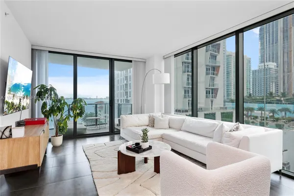 a living room with furniture and a floor to ceiling window