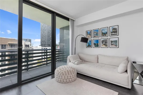 a living room with furniture and a floor to ceiling window