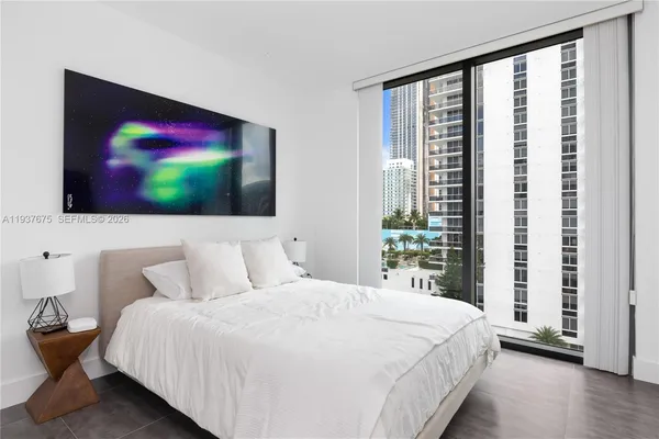 a bedroom with a bed and a flat screen tv