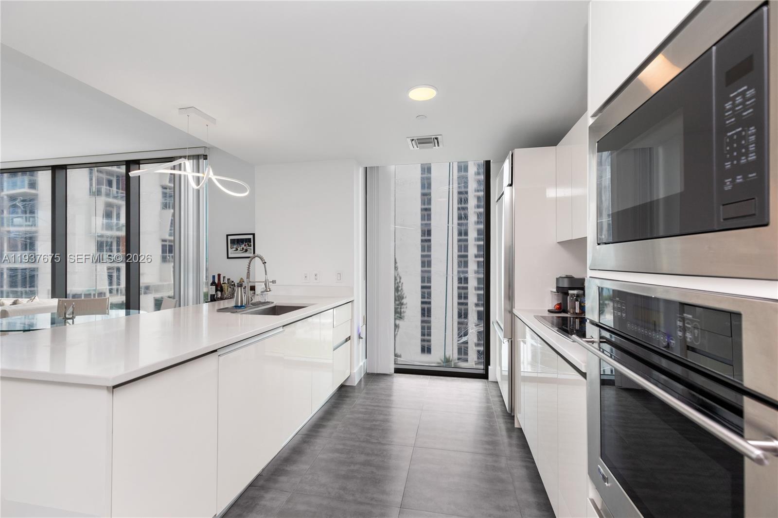 460 Northeast 28th Street, Unit 808 Miami, FL 33137 - Photo 23 of 41 a large kitchen with stainless steel appliances a sink and a stove