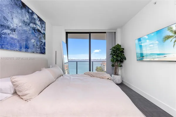 a bedroom with a large bed and a painting on the wall