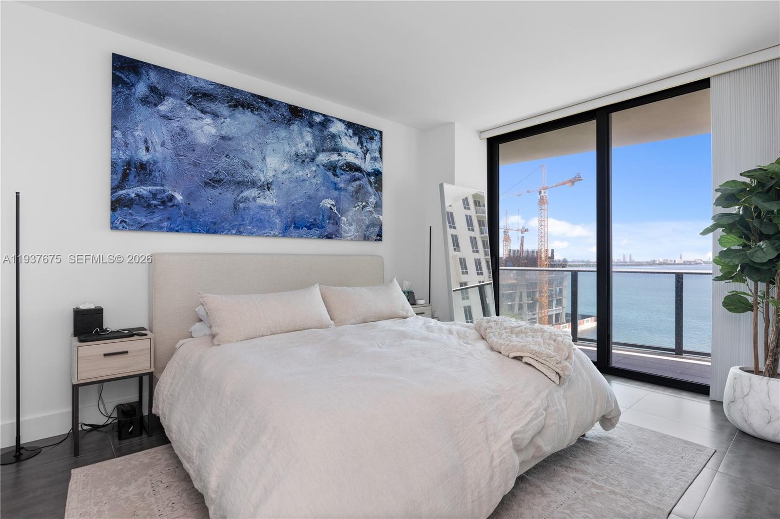 460 Northeast 28th Street, Unit 808 Miami, FL 33137 - Photo 25 of 41 a bedroom with a large bed and a painting on the wall