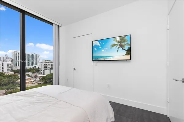 a bedroom with a large bed and a potted plant