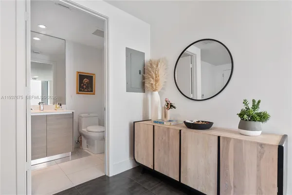 a bathroom with a toilet a sink a mirror and a window