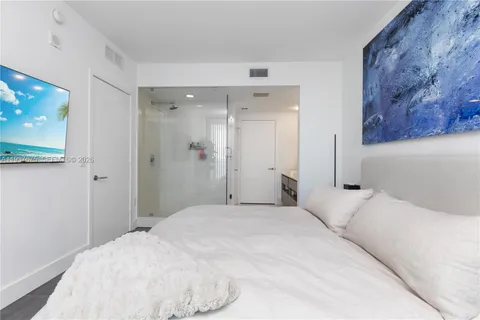 a bedroom with a bed and a painting on the wall