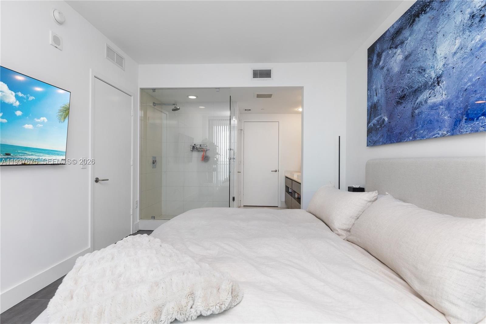 460 Northeast 28th Street, Unit 808 Miami, FL 33137 - Photo 9 of 41 a bedroom with a bed and a painting on the wall