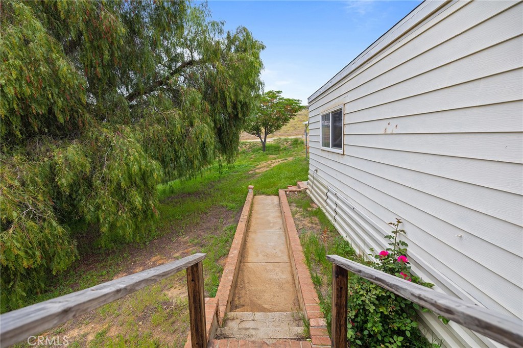 24469 Manzanita Road Menifee, CA 92584 - Photo 19 of 20 a view of a pathway of a house with a yard