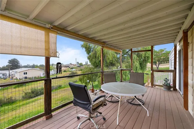 a view of a balcony with chair and wooden floor