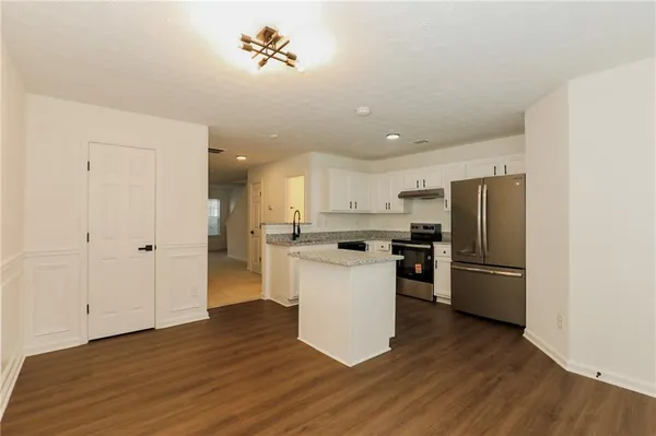 a kitchen with a refrigerator and a stove top oven