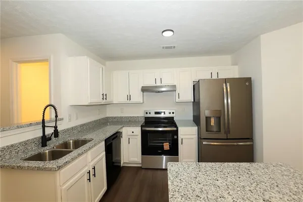 a kitchen with stainless steel appliances granite countertop a sink stove and refrigerator