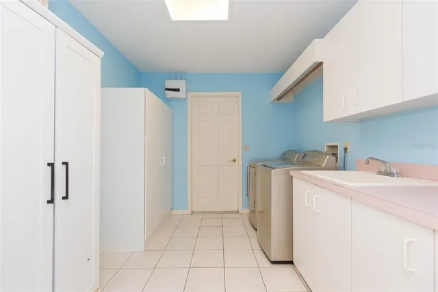 a utility room with cabinets washer and dryer