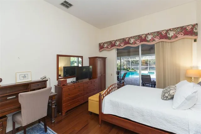 a bedroom with a bed window and wooden floor