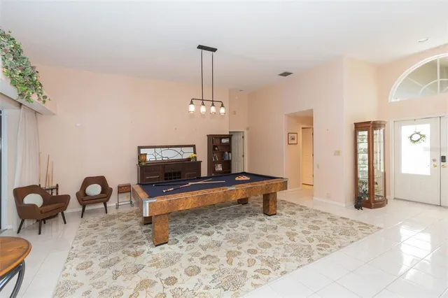 a living room with furniture a dining table and a chandelier