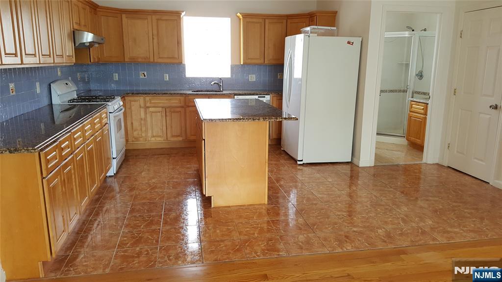 351 Main Avenue Wallington, NJ 07057 - Photo 5 of 9 a kitchen with a sink a refrigerator and cabinets