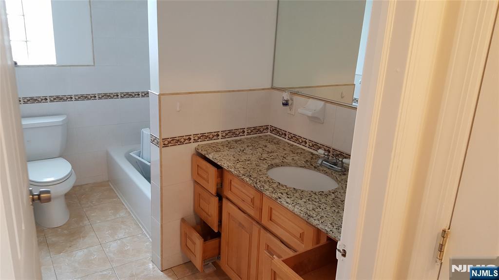 351 Main Avenue Wallington, NJ 07057 - Photo 6 of 9 a bathroom with a granite countertop sink and a toilet