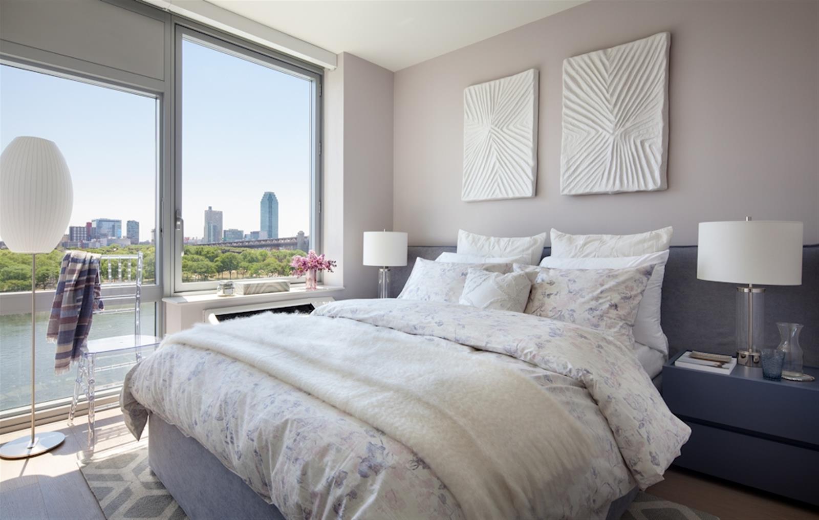 480 Main Street, Unit 20J Manhattan, NY 10044 - Photo 17 of 17 a large bed sitting in a bedroom next to a window