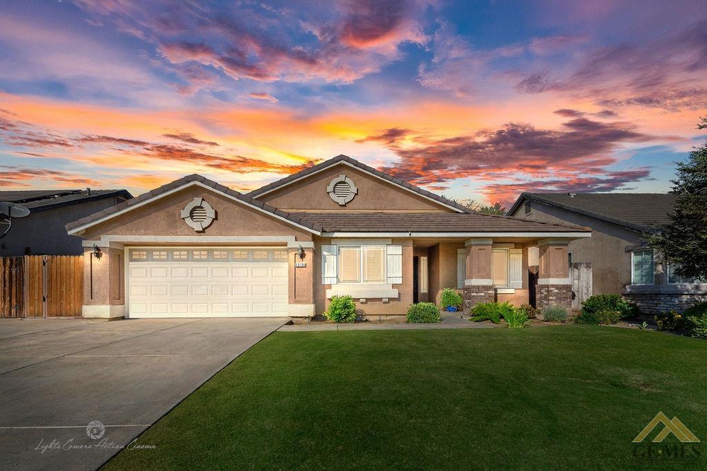 a view of a house with a big yard and large tree