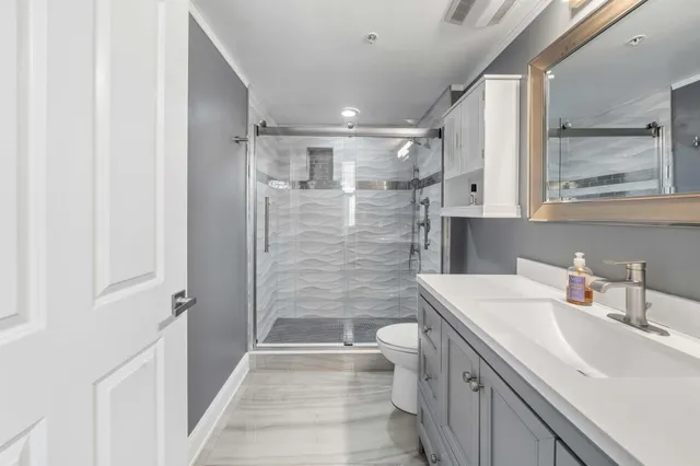 a bathroom with a sink a toilet and shower