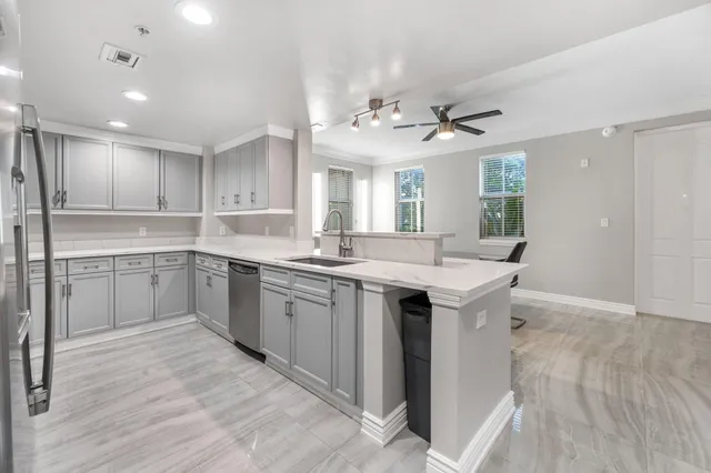 a kitchen with a refrigerator sink and cabinets
