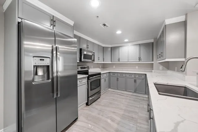 a kitchen with stainless steel appliances kitchen island granite countertop a sink and cabinets