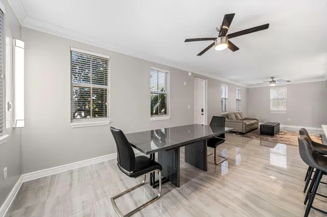 a living room with furniture a window and a ceiling fan