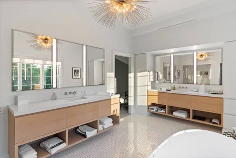 a bathroom with a tub double vanity and a large window