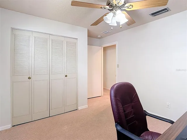 a bedroom with a bed ceiling fan and a fireplace
