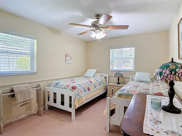 a view of a patio with table and chairs potted plants and floor to ceiling window
