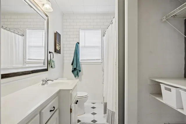 a bathroom with a sink a toilet and mirror