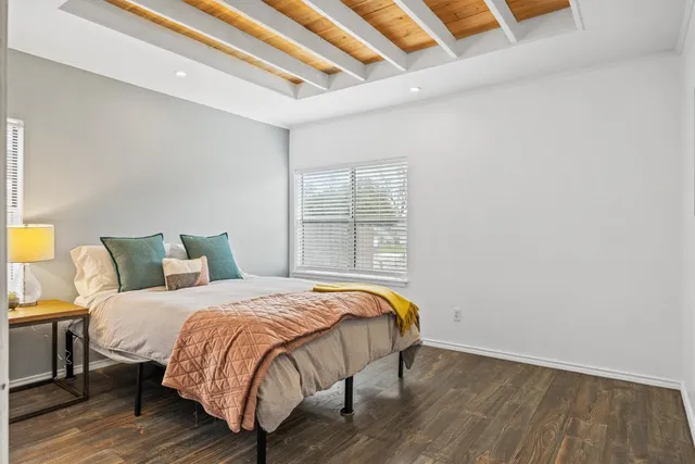 a view of a backyard with plants and large tree