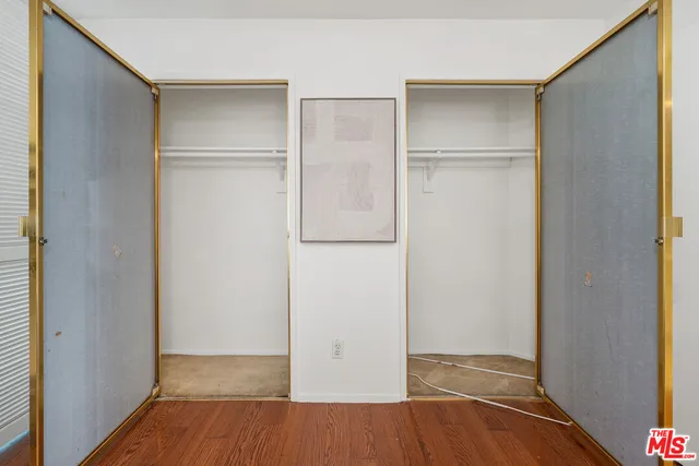 a view of walk in closet with empty racks