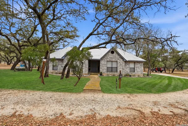 a view of a big house with a big yard and large trees