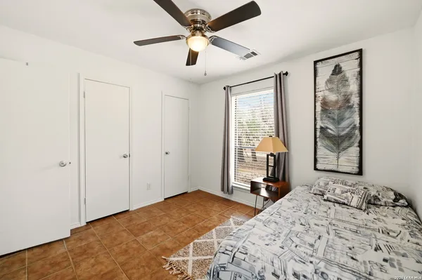 a spacious bedroom with a bed and a ceiling fan
