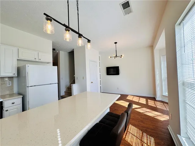 a kitchen with stainless steel appliances a refrigerator and a fireplace