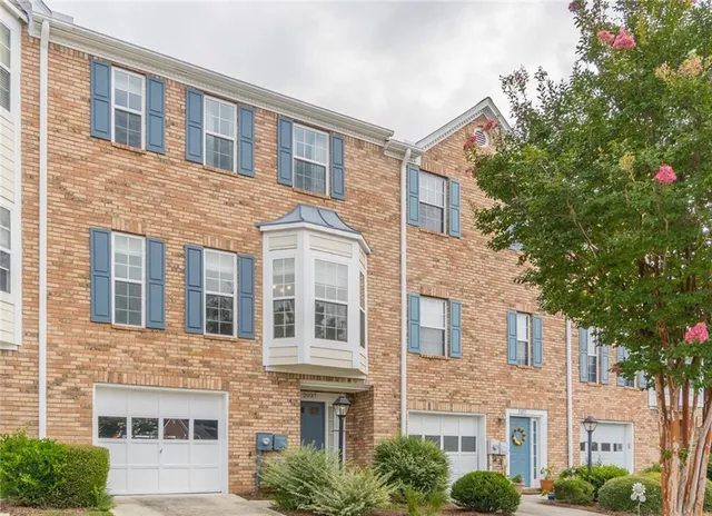 a front view of a brick building next to a yard
