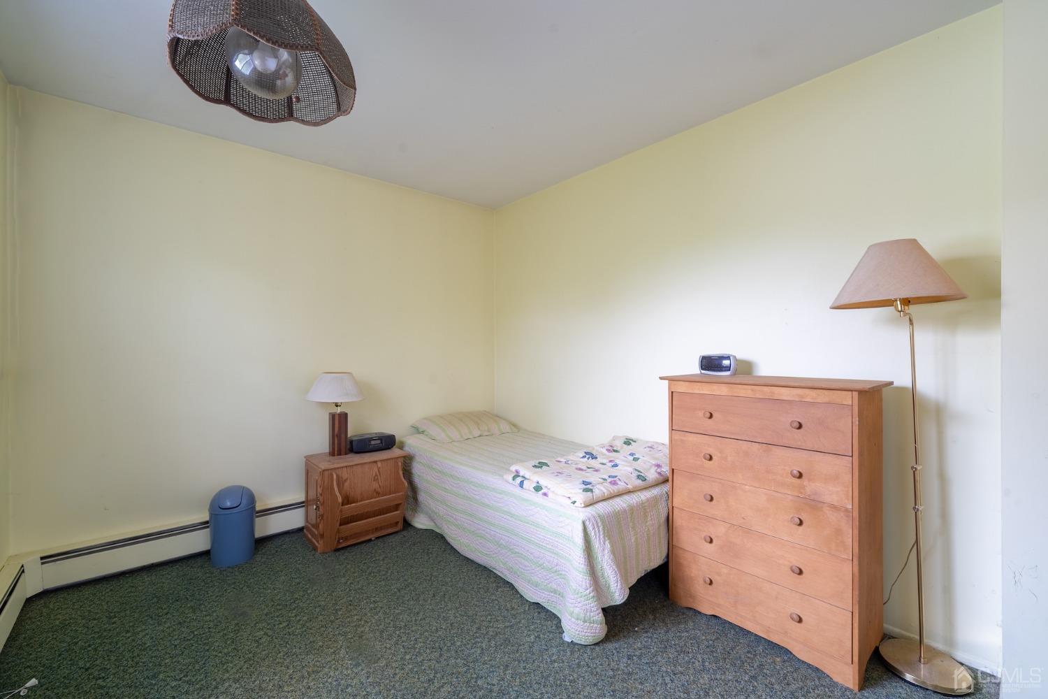 92 Kendall Road Kendall Park, NJ 08824 - Photo 11 of 28 unfurnished bedroom featuring a baseboard heating unit and dark colored carpet