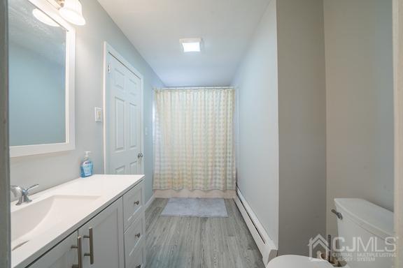 92 Kendall Road Kendall Park, NJ 08824 - Photo 8 of 28 bathroom with hardwood / wood-style floors, vanity, toilet, and baseboard heating