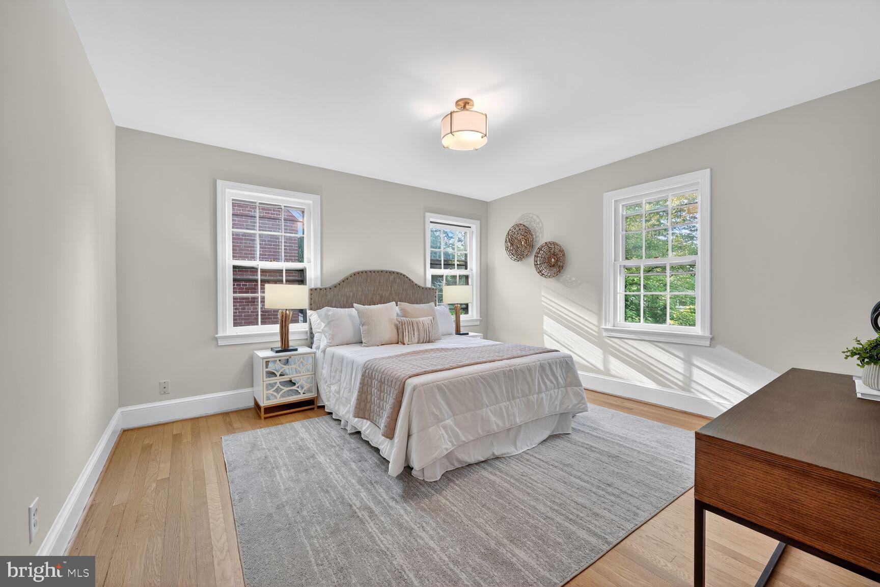 3293 Worthington Street Northwest Washington, DC 20015 - Photo 19 of 45 a bedroom with a large bed a chandelier and windows