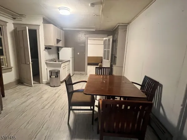 a view of a dining room with furniture and a refrigerator