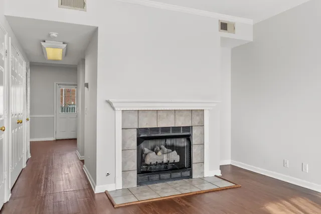 an empty room with fireplace and wooden floor