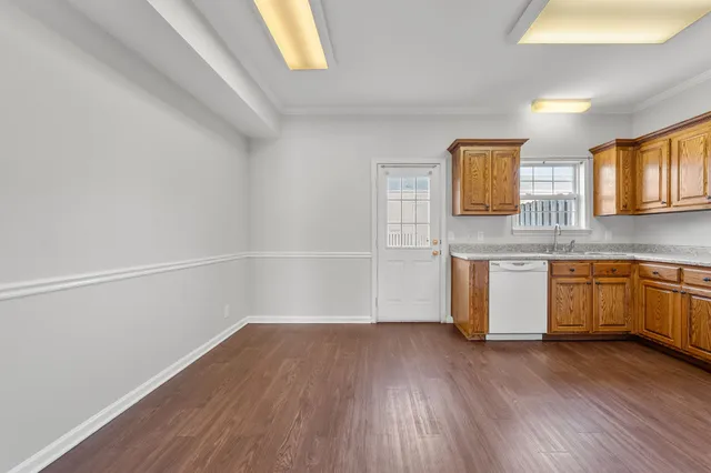 a view of a kitchen with wooden floor and a window