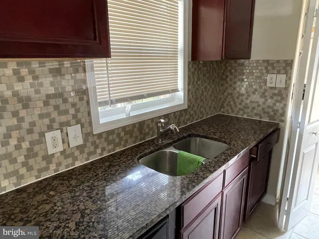 a kitchen with granite countertop a sink and a stove