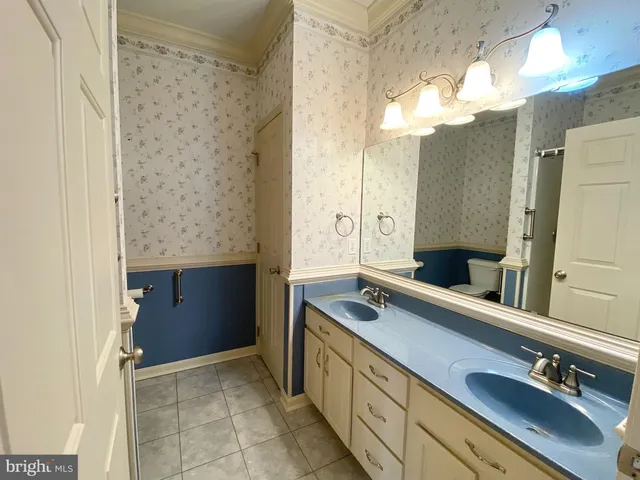 a spacious bathroom with a double vanity sink and a mirror