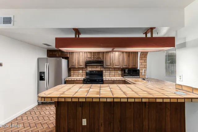 a kitchen with stainless steel appliances granite countertop a stove and a refrigerator