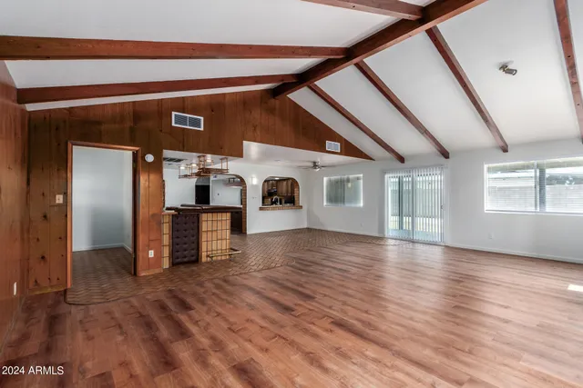 a view of empty room with wooden floor and fireplace