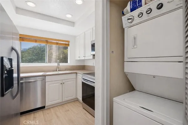 a view of washer and dryer with kitchen in the background