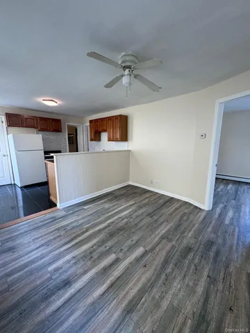 a view of a livingroom with wooden floor and a ceiling fan