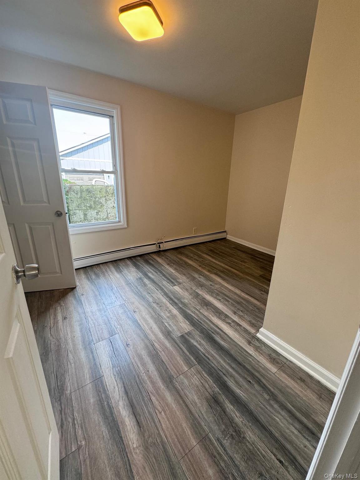 77 Cottage Street, Unit 1 Poughkeepsie, NY 12601 - Photo 7 of 13 an empty room with wooden floor and windows