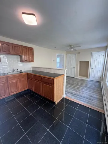 a kitchen with granite countertop a sink a stove counter space and cabinets