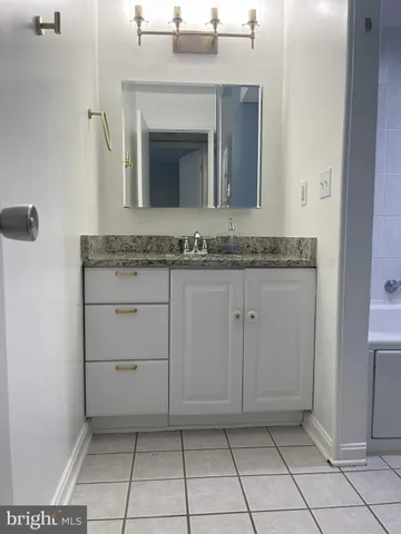 a bathroom with a granite countertop sink and a mirror